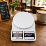 Portable SF-400 digital kitchen scale on cafe table with stylish background.