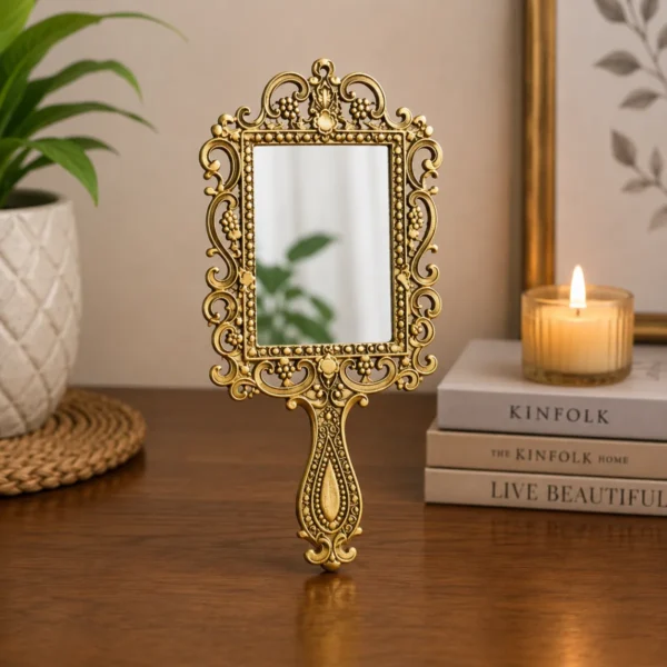 Elegant square shape gold plated metal hand mirror displayed on stylish vanity table décor