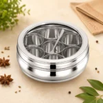 Premium stainless steel masala dabba with transparent lid and elegant spice-themed background.