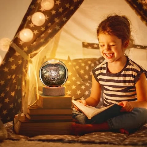 Beautiful crystal universe night lamp creating a cozy reading environment for children.