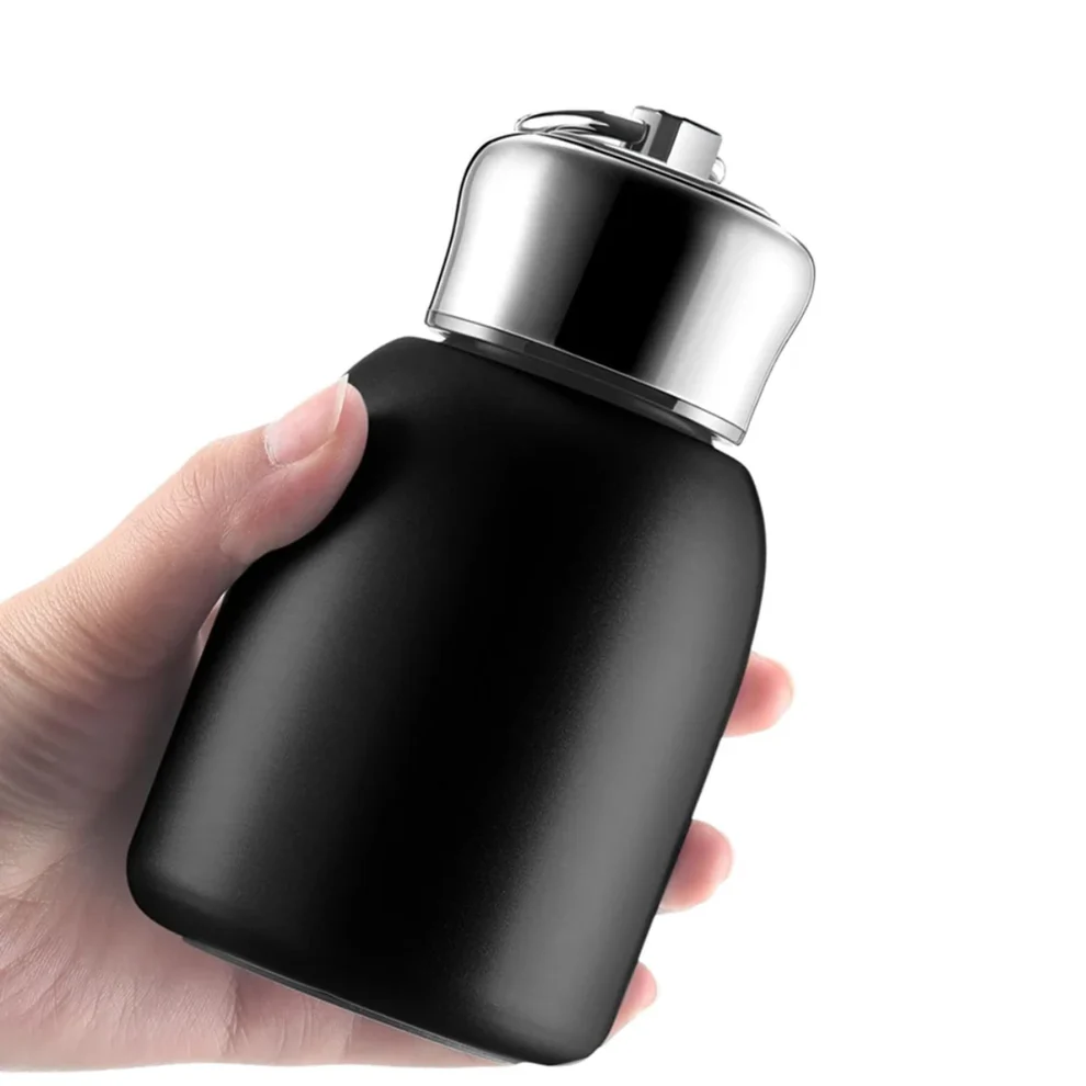 Compact reusable insulated water bottle with premium steel cap held comfortably in hand.