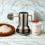 Professional coconut scraper displayed in kitchen with freshly grated coconut and ingredients.